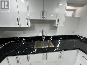 Toronto (Blake-Jones) apartment for rent - A modern kitchen with a marble countertop and white cabinets.