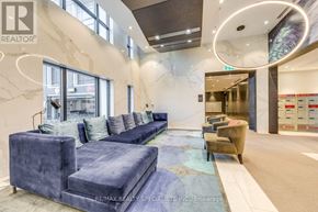 Toronto (Islington-City Centre West) condo for rent - A blue couch and a brown chair are in a room with a marble wall.