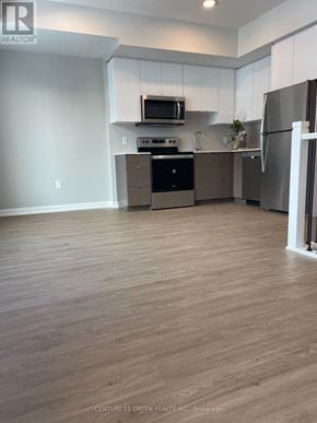 Guelph (Riverside Park) townhouse for rent - A kitchen with wooden floors and stainless steel appliances.