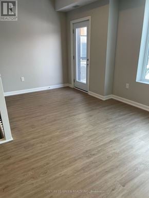 Guelph (Riverside Park) townhouse for rent - A room with light wood flooring and a doorway leading to a balcony.