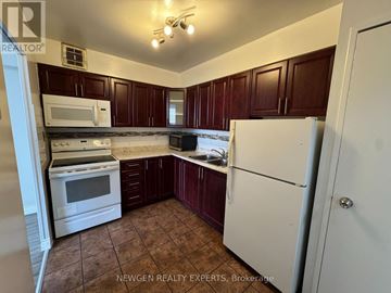 Toronto (Flemingdon Park) condo for rent - A kitchen with brown cabinets and white appliances.