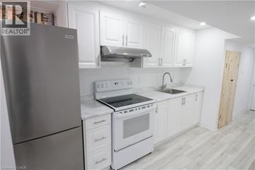Waterloo apartment for rent - A modern kitchen with white cabinets and a stainless steel refrigerator.
