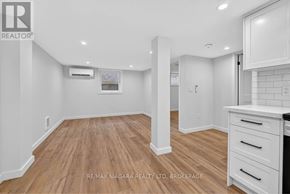 Niagara Falls (Chippawa) apartment for rent - A spacious kitchen with white cabinets and a wooden floor.