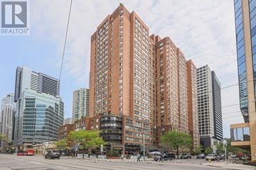 Toronto (Bay Street Corridor) condo for rent - A tall red brick building is in the middle of a city street.