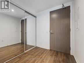 Toronto (Moss Park) condo for rent - A room with a sliding door and a wooden floor.