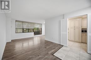 Toronto (L'amoreaux) condo for rent - A spacious room with wooden flooring and a large window with blinds.