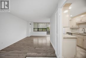 Toronto (L'amoreaux) condo for rent - A spacious, empty room with wood flooring and white walls.