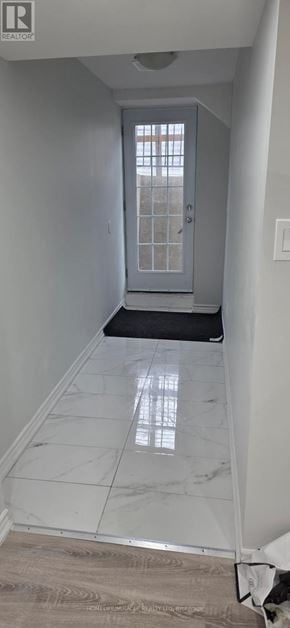 Toronto (Rouge) townhouse for rent - A hallway with a white door and a tiled floor.