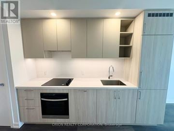 Vaughan (Vaughan Corporate Centre) condo for rent - A kitchen with a sink, stove and cabinets.