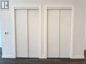 Vaughan (Vaughan Corporate Centre) condo for rent - Two white doors in a room with a logo on the wall.