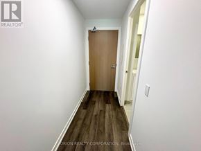 Vaughan (Vaughan Corporate Centre) condo for rent - A hallway with a wooden door and a white wall.