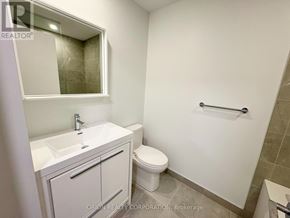 Vaughan (Vaughan Corporate Centre) condo for rent - A white bathroom with a toilet, sink, and mirror.