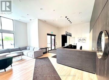 Milton (Co Coates) condo for rent - A modern living room with a grey sofa and a wooden floor.