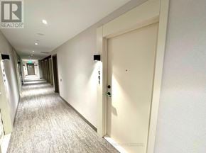 Milton (Co Coates) condo for rent - A hallway with a door on the right and a sign on the wall.