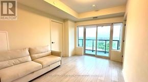 Milton (Co Coates) condo for rent - A living room with a couch and a view of the ocean through the sliding glass doors.