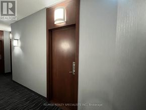 Toronto (Bay Street Corridor) condo for rent - A hallway with a brown door and wall lights.