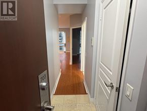 Toronto (Bay Street Corridor) condo for rent - A hallway with a door on the right and a sign on the wall.