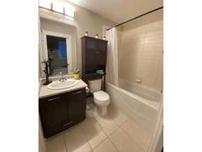Surrey apartment for rent - A bathroom with a white toilet, sink, and bathtub.