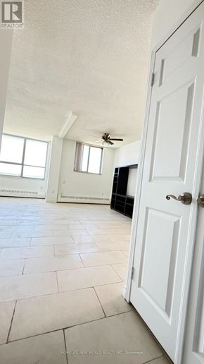Toronto (Yorkdale-Glen Park) condo for rent - A white door is open in a room with a ceiling fan and a window.