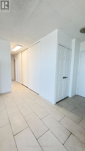 Toronto (Yorkdale-Glen Park) condo for rent - A hallway with white doors and tiled flooring.