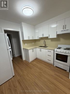 Toronto (Lansing-Westgate) multi-family for rent - A kitchen with white appliances and wooden floors.