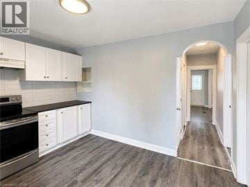 Hamilton apartment for rent - A kitchen with white cabinets and a black stove top oven.