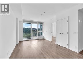 Port Moody apartment for rent - A spacious room with a large window and wooden flooring.