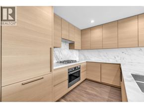 Port Moody apartment for rent - A modern kitchen with wooden cabinets and a marble backsplash.