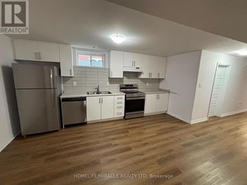 Bradford West Gwillimbury (Bradford) apartment for rent - A kitchen with white cabinets and a wooden floor.