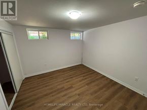 Bradford West Gwillimbury (Bradford) apartment for rent - A room with wooden flooring and two windows.