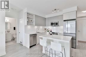 Mississauga (Central Erin Mills) condo for rent - A modern kitchen with white cabinets and a breakfast bar.