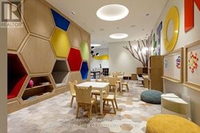 Toronto (Etobicoke West Mall) condo for rent - A room with a wooden hexagon wall and a white table with chairs.