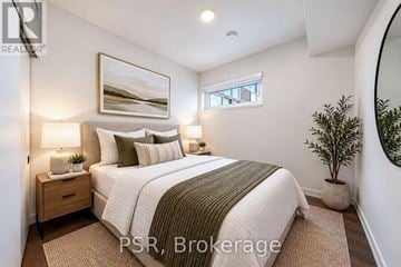 Toronto (Niagara) condo for rent - A bedroom with a large bed, a nightstand with two lamps, a framed picture on the wall, and a potted plant.