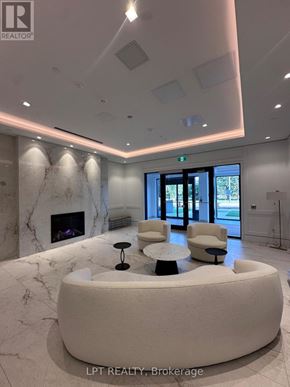 Toronto (Humber Heights) condo for rent - A reception area with a marble fireplace and a white circular table.