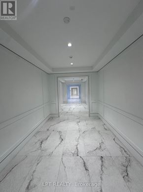 Toronto (Humber Heights) condo for rent - A long hallway with marble floors and white walls.