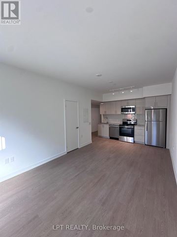 Toronto (Humber Heights) condo for rent - A spacious kitchen with stainless steel appliances and wooden flooring.
