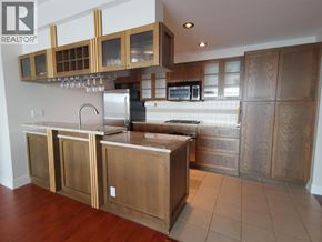 Vancouver apartment for rent - A kitchen with wooden cabinets and a stainless steel refrigerator.