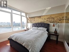 Vancouver apartment for rent - A bedroom with a large bed and a view of the city.