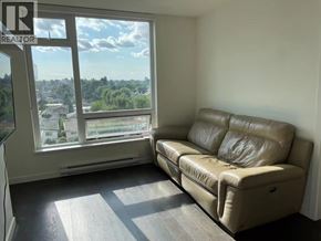 Vancouver apartment for rent - A tan leather couch sits in a room with a window overlooking a city.
