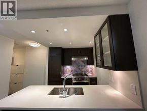 Vancouver apartment for rent - A modern kitchen with black cabinets and a white countertop.