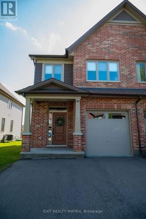 Russell townhouse for rent - A brick house with a garage door and a wreath on the door.