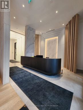 Mississauga (Cooksville) condo for rent - A reception area with a black reception desk and a blue rug.