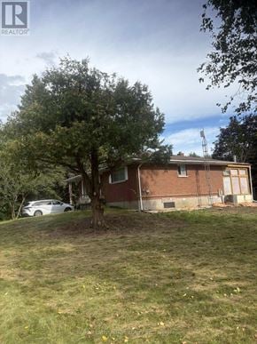 Clarington apartment for rent - A tree in front of a house with a car parked in the driveway.