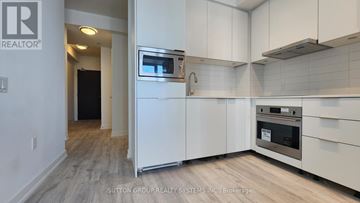 Toronto (Newtonbrook East) condo for rent - A modern kitchen with white cabinets and stainless steel appliances.