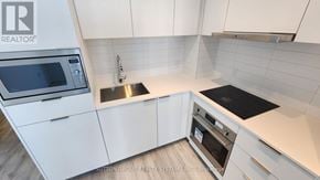 Toronto (Newtonbrook East) condo for rent - A modern kitchen with white cabinets and stainless steel appliances.