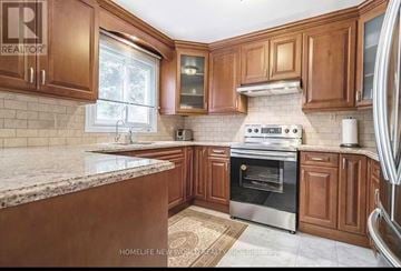 Mississauga (Erin Mills) apartment for rent - A kitchen with wooden cabinets and a granite countertop.