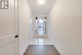 Brantford apartment for rent - A hallway with a door on the left and a view of a city through a window on the right.
