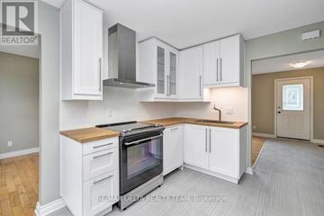 Ottawa apartment for rent - A kitchen with white cabinets and a wooden countertop.