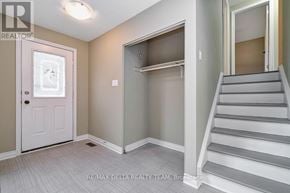 Ottawa apartment for rent - A white door is on the left of a hallway with a staircase on the right.