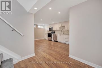 Ottawa apartment for rent - A kitchen with white cabinets and a wooden floor.